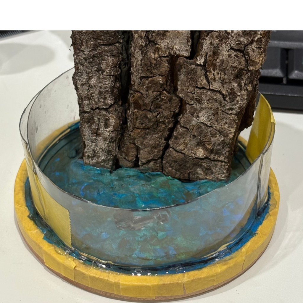 粘土を水ぞこっぽい模様に塗った後、レジン注入のため周りをペットボトルの切り抜きで囲い。