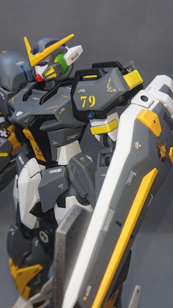 カラーリングは、キャメルイエローをメインカラーにジャーマングレイとブラックでまとめてみました💡イエロー系の色をメインカラーに使うことが少ないので自分としては新鮮な気持ちで塗装が出来て楽しかったですねw今回のストライクは遠隔攻撃がメインの機体なので、機体各所にセンサーを表現するためメタリック系のブルーやグリーンを多めに入れるようにしています!特に拘っているのが左側のストライクの肩フレームにセンサーを追加しているところです元々、ストライクの肩フレームには丸いポッチのようなデザインがあるのですが、そこを削り落としてMSGの“丸ノズル(S)”に収録されているサイズが3.0の丸ノズルを接着してセンサーっぽく表現してみました✨あと、ちょっとした遊び心で頭部のツインアイを青と緑のオッドアイにしていますw