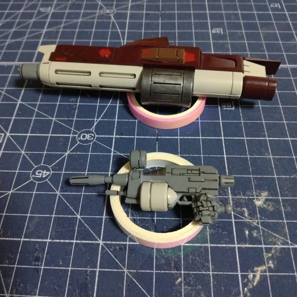 武装とシールドです。フレームランチャーは細々と塗り分けてみました。また発射口の上は、何かディテールがありスコープではないようですが、MG版がそうなっているし、たた周りと同じ色だと寂しいので、緑のラピーテープを貼ってスコープらしくしてやりました。シールドのヒンジはひけをパテで埋めてやりましたが、組み立てた後に畳んでみたら、一撃で折れてしまいました。（1枚目）