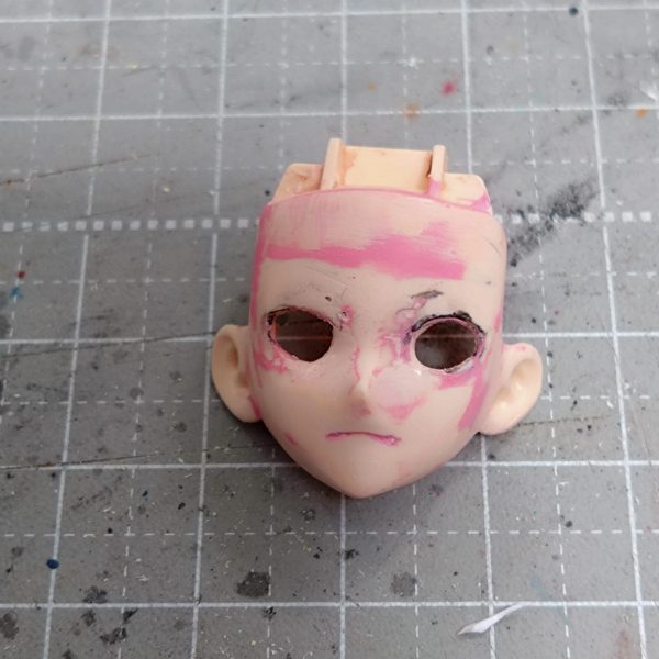 よくよく目的のキャラ画像見ながら目蓋周りの形をランナーくずと流し込み接着剤で少し変えてます。表面と形確かめるためにピンクサフ筆塗りしたりヤスったり、まつ毛ライン描いてみたりヤスったり。口周りも少し変更、輪郭も少しシャープにしてみてます。眼球パーツが中に入り過ぎなのでプラ板貼って厚み出し中です。硬化後顔パーツに合わせながら少しずつ修正かけます。Netflixで確認してみたら髪型の後側ばっちり出てたのでこれも今後修正とザックリ作った前髪ももう少し位置関係の調整で多分やり直し…まだまだ先は長そうです。（1枚目）
