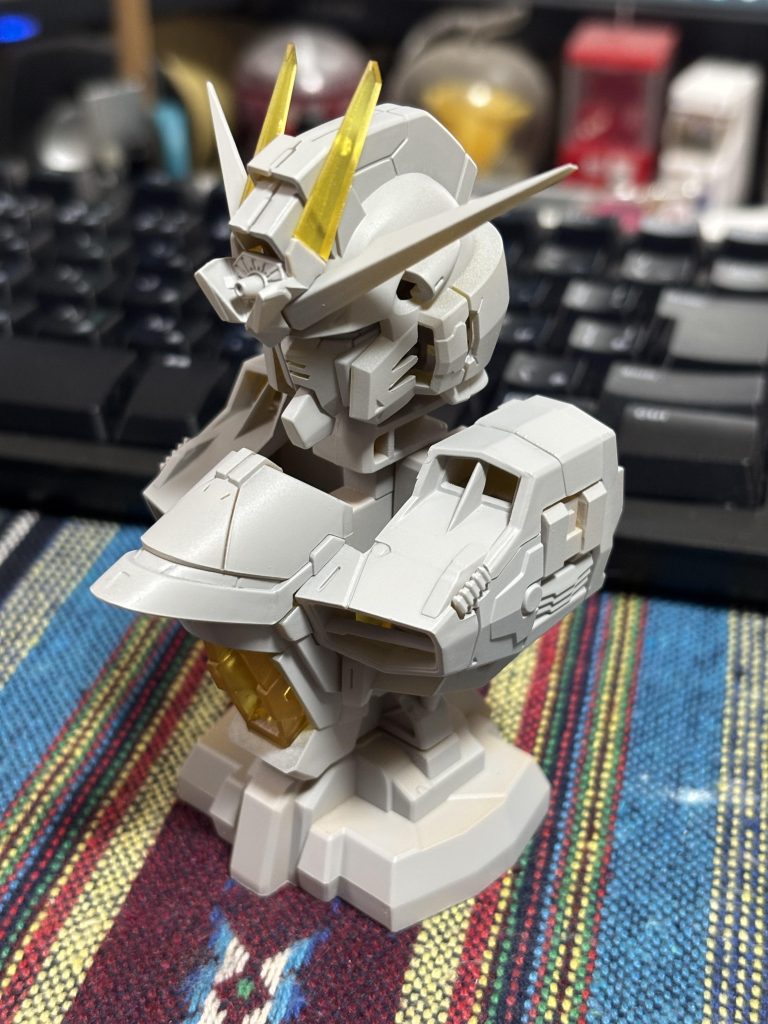 　グレーサフを吹いた状態です。　ディテールが出てきた感じがあって、一気に姿が締まりました。はっきり言って、これだけでも十分にかっこいいです（二度目）。　せっかくなので、ブレードアンテナと胸部はクリアーのまま残すことにしました。メカニカルバストはヒケ等が酷いと聞いていたのですが、全く目立たなかったので1回目のサフでそのまま進みます。また、合わせ目加工は全くしていません。　ちなみに、メカニカルバストは素材は、ラッカー等の溶剤と非常に相性が悪いABSが使われているのですが、通常のキットのように細かいはめ合わせがあるわけでなくテンションもそうかからないだろうということでプライマー抜きにラッカーサフ（ガイアノーツのサーフェイサーエヴォ）を吹いてます。特に問題はなさそうでした。