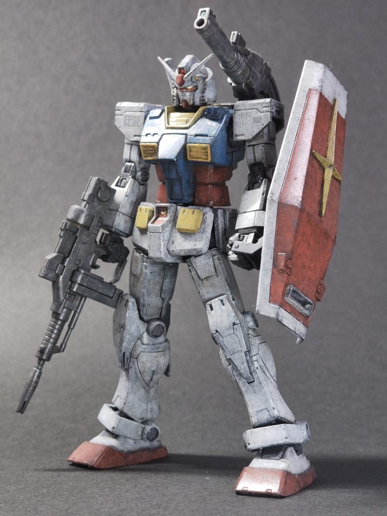 いきなり反省を踏まえて塗装レシピ。いつもサフにメカサフヘビィでしたが、アクリジョンのベースグレーを代用、後は水性ホビーカラーはいつも通り。オール筆塗り、オール水性です。白: スーパーファインシルバー > ディアクティブホワイト > グランプリホワイト青: ライジングフリーダムブルー > ガンダムエアリアル改修型ブルー赤: モンザレッド > サーモンピンク黄: ハイネ専用機オレンジ > オレンジイエロー > ガンダムイエローバックパック、武器: 焼鉄色 > 軍艦色(1)、 グレーバイオレット関節:  軍艦色(1)チッピングはシールドだけでダークブランウォッシング締め。後で気がついたんですが、サフ代わりのアクリジョンの塗りが厚くて(ほぼ瓶生で塗っため)、所々ムラが残っていて、最後までムラが影響してしまっている箇所があり、胸の一番でっぱってるパネルに目立つムラがあったのでそこだけヤスリで地まで削ってやりなおしました。検証なしの一発本番運用はダメです。 