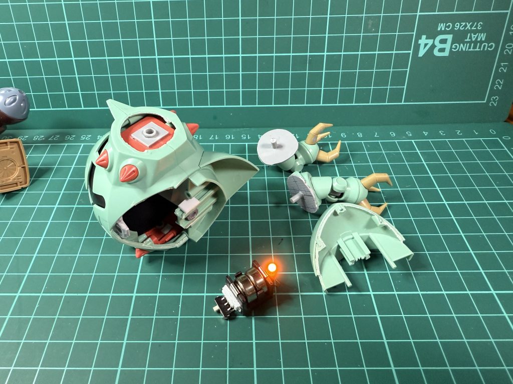 LEDは1.5Vのボタン電池2個使用。スライドスイッチでON/OFFできます。モノアイのつく黒い部分やピンクのメガ粒子砲のパーツは挟み込みで後ハメ加工は無理そうだったので、塗装後に接着・合わせ目消しし、マスキングして合わせ目箇所を再塗装しました。