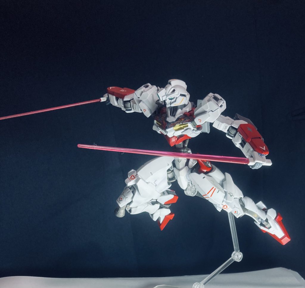 以下脳内設定XGF-001A ガンダム・ルブリス・アンスール開発：オックスアース社分類：GUNDフォーマット試作汎用型MS■ 概要XGF-001A「ルブリス・アンスール」は、A.S.101年時点でオックスアース社のMSカタログに掲載されていた、ルブリス系統の多数あるバリエーションのひとつである。もしルブリスの販売計画が順調に進んでいれば、アンスールは戦場で実戦投入されていた可能性のある試験機であった。標準装備は大腿部ウェポンコンテナに収納されたビームサーベルと、腕部固定型特殊マルチランチャーユニットの二種のみ。一見すると装備が少なく見えるが、これはむしろ冗長性を排したモジュラー設計の証であり、肩部・バックパック・ウェポンコンテナ部に多数のハードポイントを有する。これによりアンスールは、装備の換装によって多様な戦局に対応できる汎用フレームとして設計されている。なお、本機のバックパック形状はガンヴォルヴァのそれと酷似しており、後年のガンヴォルヴァ開発時にアンスールのバックパック構造が設計資料として参照されたと考えられている。■ 開発経緯当初、アンスールはGUNDフォーマットによる高機動・近接格闘戦に特化した機体として開発が始まった。しかし開発後期において、オックスアース社上層部の意向により「多目的換装型MS」へとコンセプトが変更され、設計全体の再調整が行われた結果、機体の方向性が大きく変化した。そのため、素体は高機動近接寄りのフレーム構造を持ちながら、外装は汎用性を重視した高機動タイプへと移行しており、結果的に「格闘寄りの汎用機」という中間的な性能に落ち着いている。開発関係者からは「中途半端な機体」と揶揄されたが、実際には特定装備とのマッチング次第で特務機を凌駕する潜在力を秘めている。なお、設計変更後も既に完成していたインナーフレームの仕様を改修することはできなかったため、内部構造は初期設計の近接特化型インナーフレームのままとなっている。その名残として、アンスールの腕部関節フレームは極めて高い強度と即応性を誇る。■ 武装解説● 特殊マルチランチャーユニット両腕部に内蔵された多目的射出装置。専用弾頭「ガンバレッド」を使用し、MSの関節部やセンサーなどの弱点を精密に狙うことを目的としている。このガンバレッドは、いわばガンビットの実弾版と呼べる存在であり、GUNDフォーマットによる精密制御を活かして標的追尾を行う。「水星の魔女」世界におけるMS群の多くが実弾兵器を排している中で、アンスールがあえて実弾武装を採用しているのは、このガンバレッド運用のための構造的必然である。● 大腿部ウェポンコンテナ標準ではビームサーベルを収納するが、コンテナ内部はモジュラー化されており、小型ミサイル、ガンバレッド拡張弾倉、索敵ビーコンなどの多用途ユニットを搭載可能。■ 評価と影響ルブリス・アンスールは、明確な方向性を持たない試験機として開発を終えたが、その汎用性の高さとフレーム柔軟性は後年のGUND-ARM研究で高く評価された。特に「換装による特化再現」という思想は後のファラクトアンスール等の、アンスールを母体とした各種再現バリエーションへと受け継がれていく。