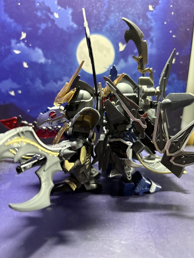 まず二体の後ろの腰パーツを外し、武呂飛天司の物を零示縁鴑に装着零示縁鴑の頭と腰、足首を半回転させて武呂飛天司の背中の羽根（郭嘉ヴァサーゴの羽根）と接続武呂飛天司もアンテナを下げて、別パーツの顔を装着足首も前後を入れ替え