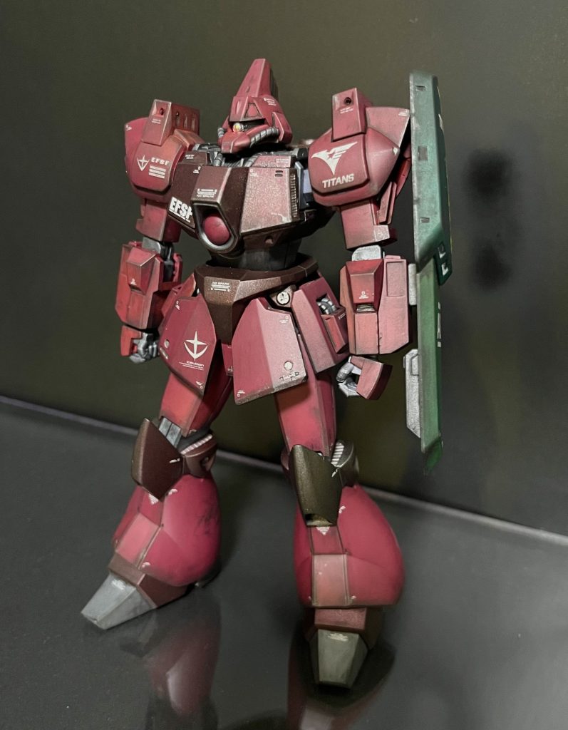 てなこって完成です、ガルバルディβ機体色は全体的に暗めに、ピンク部分はシャアレッド、ブラウンっぽいところはメタルグレイの上にクリアレッドで赤みを少し付けてます。缶スプレー塗装ですのでなかなか出したい色を出せないのが難点ですね。デカールは前述の通り、連邦機体だけど後付けでティターンズ仕様にしましたよ感を出すためにわかりやすい位置に１箇所とシールドに１箇所ティターンズをマークドしてます。モノアイはドームパーツに替えてますが設定上十時のラインが入るので薄くモールドを彫って墨を流してうっすらぽく見えるようにはしてみてます。