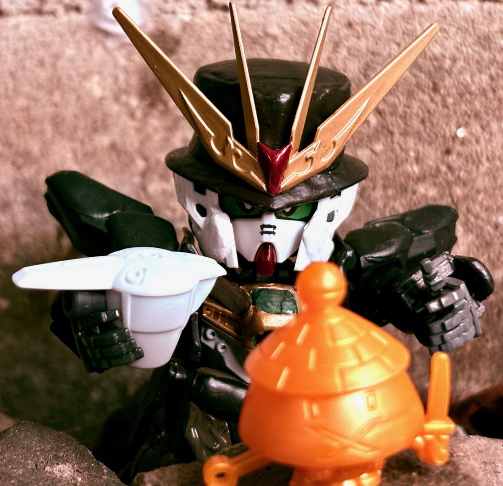 ※写真は1作目のオマージュ。インディガンダムDX(脳内CV:村井國夫)は元ネタ同様、考古学者として活躍。世界各地を股にかけた著名なトレジャーハンターである。アルセーヌガンダムと異なる点は発見した財宝を博物館に収める事で盗掘者から守り、収入を得ている点である。馬に車、ボート、飛行機果ては古代の機械人形(モビルスーツ)の操縦もこなし、銃火器の扱いもお手の物。腕っぷしも悪運も強い男。人間の年齢に換算すると35~40歳くらいのナイスミドルであり、知的で真面目な性格だがキザで女たらしな一面も持つ。冒険の途中で彼を「先生」と呼び慕う少年ガロードと不思議な力を持つ少女ティファと出会い、以後行動を共にする。ひそかにガロードを自分の後継者にしようと考えている(インディ曰く、「彼のまっすぐな性格が若い頃の自分と似ている」から)。