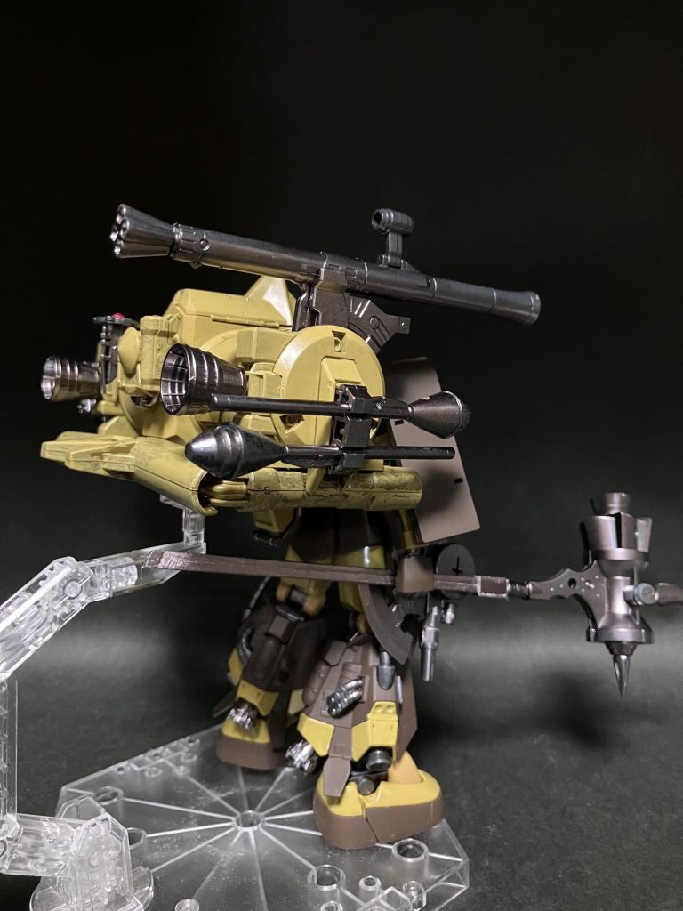 長い柄にスパイクの付いた槌となっている。特徴的なのはそのスパイクの反対側にバーニアがある。技師長「私らはジェットハンマーって呼んでました。」なかなかに凶悪な武器だが、これなら大型戦艦も落とせるだろう。火器で撹乱しながら高速で接近しジェットハンマーでの攻撃。そんな戦闘イメージをマサヤがしていると、声を掛ける者がいた。助けた少年らである。少年兵「中尉、改めて助けて頂きありがとうございます！ただ情けないですが、自分達はもう戦場には戻れません。だから中尉のこの機体の整備を必死でやりました。」マサヤは驚いた。少年兵は泣きながらそう言ってきたからだ。こんな年端もいかない少年にとって、戦場がどれほど恐怖の場所であったか。戻れないとて、当然の話だ。それに対し、こんなにも責任を感じてしまうものなのかと......。マサヤ「君らは私をここまで連れてきてくれた。恐怖の戦場の中で、荷物となる私のザクを。あの状態のままだったら私も今頃助かっていなかっただろう。戦場で私も救われた。ありがとう。」少年らはその言葉に安堵し、より激しく泣いてしまった。