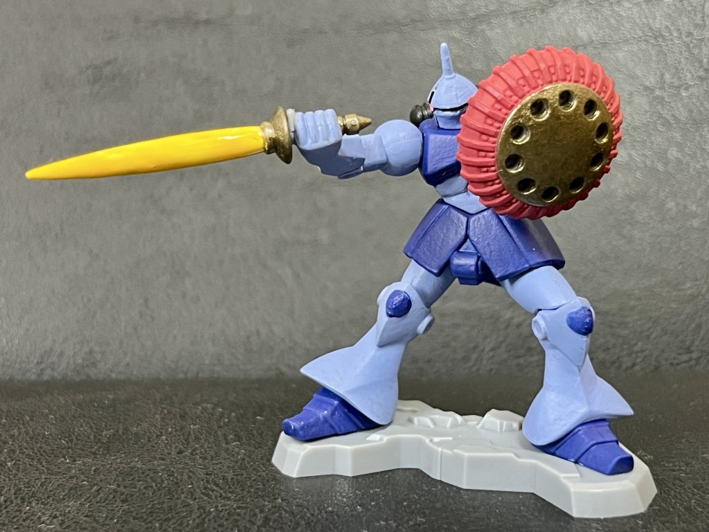カラーレシピは以下の通りで、仕上げにシールドとサーベル以外につや消しトップコートを吹いています。頭部、腕、脚部:すみれ色胸部、スカート部、足部:コバルトブルーシールド周縁部:ベースレッドシールド中央部、サーベルの鍔と柄、バックパックの下部:アンティークゴールドサーベル刃:蛍光イエローモノアイ:ベースホワイト→蛍光ピンクバックパック上部、モノアイ周辺:つや消しブラック
