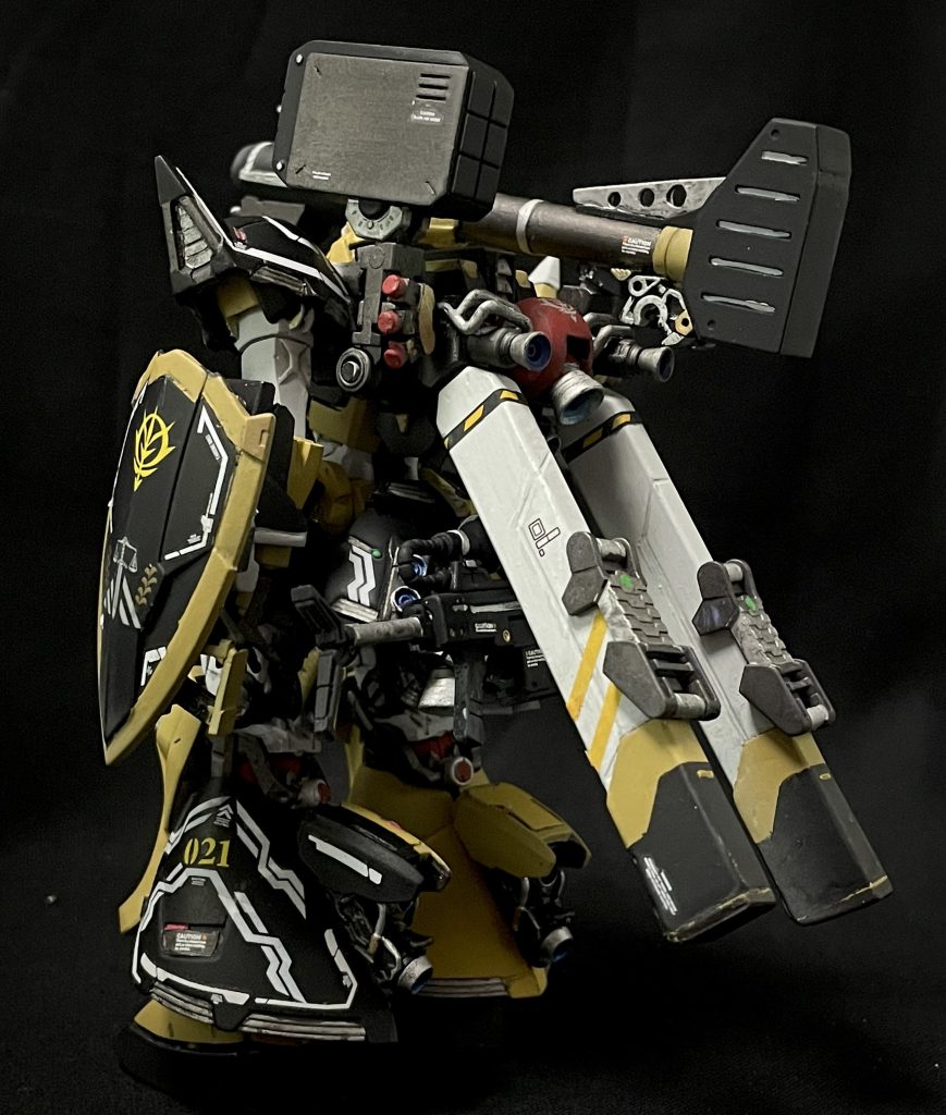 バッグパックはキマイラ隊小隊行動の為大型化されており、プロペラントタンクを装備し長時間運用を想定し、スナイパーの特性からスモークディスチャージャーを装備している。