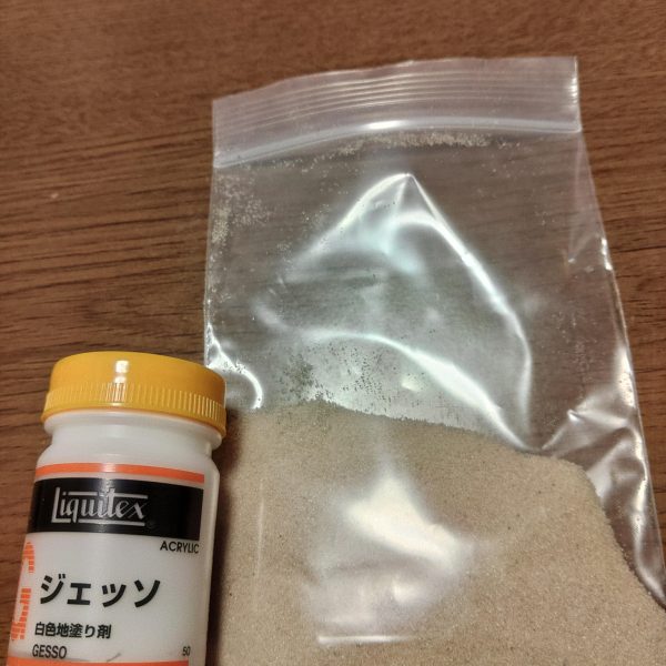 ステージと言った方がいいでしょうか？ 砂浜と波打ち際を作製中です。砂浜はクラフトサンドにリキテックスのマットメディウムを混ぜたものです。白い部分はリキテックスのジェッソ。乾燥後着色して、上からジェルメディウムを置いて、波を作ります。 砂浜が分厚いので乾燥に時間がかかってます。（2枚目）