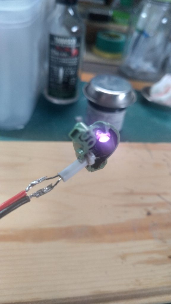 LED部の背面にエポパテでいい感じの位置になるよう台座を作り、瞬間接着剤で固定。導線をLEDの端子にハンダ付けし、点灯確認。
