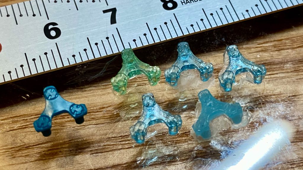 ◼️ 頭部を作る説明書も順番も頭部から作るという事になっているので、作り始めたのですが、作る前から”ゲルググのセンサー部分ってどうなってるの?”という疑問があり、アニメをコマ送りで観察したりしたのですが、納得のいく答えを得られずにいました。しかし、プラモのパーツを見るとバイザーの奥に3眼カメラのモールドがあるではないですか! つまり、バイザーの奥にセンサーのレンズが3つあるという事で、じゃぁバイザーの表のモールドは何?と言う次の疑問....これは僕の中で答えが出ませんでした。最終的にどうしたかというと、表のマイナスモールドは削ってしまいました。(wとりあえず、失敗もするだろうしという事でバイザーパーツ複製。youtubeを参考にUVレジンでパーツを複製して試行錯誤して透明パーツでセンサー部分のディテールアップに挑んでいたのですが、バイザーパーツの裏の凸を削って、穴の方にカメラっぽいパーツを差し込んだら良いのでは?とぼんやりと考えていたら、Xにまさにそのようにディテールアップしている方がいまして、僕の求めていた答えを得た感じがしました。バイザーの凸と同じ経で蓄光パウダーを混ぜたUVレジン棒を左右と上部の3本作り、頭部パーツの三眼目の部に穴を開け、そこにレジン棒を差し込む。 そして複製したバイザーの裏の突起を切除したパーツを嵌め込む。これ方向でいこう!と決めました。