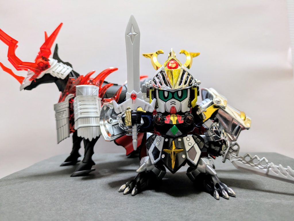 死闘をくぐり抜け、闇に囚われた弟を救うために生死をかけた修行の末に魔界の炎をまとった闇の騎馬を召喚、闇騎士の力を得る。それは、天に選ばれた武者のみが至る事ができる至高の境地〝光解〟（こうがい）の発現であった…。という設定です。闇の騎馬は「信長専用軍馬」の素組み、鎧部分のみシルバー塗装しました。鎧の黒塗装にはメタリックブラックを吹きました。元のパールホワイトの成形色が効いてイイ感じに色が乗りました。金銀メッキパーツふんだんで美しい仕上がりに。胸や肩などホイルシールを使ったところもありますが、メッキ部分には敢えて貼っていません。肩鎧には十字架のワンポイントを、腰鎧にはラインストーンでディテールアップ。どちらも100均で収穫しました。