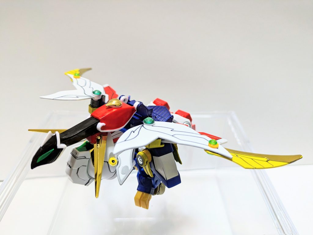 ウイングとあればバード形態に変形しないと忠実とは言えません。羽荒斗の飛翔神鳳ギミックを残しつつアレンジを効かせて実現しました。鳥の頭と背は、モチーフのライフルとシールドの色を採り入れて塗装。鎧兜を逆に被せ、肩鎧は内部にパテで仕込んだポリキャップに嵌め直すことで下向きに折る形を再現しました。