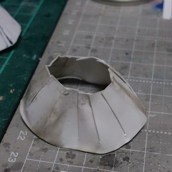 チナッガイ改造の続きです。後頭部はこんな感じになりました。スカート部分は昨日制作。腰のパーツに帯のように巻き付けたプラ板に、台形のようにカットしたプラ板を貼り合わせて制作。瞬間接着剤塗っては瞬着スプレー…でこんな感じに出来ました。 今日は昨日制作したスカートより少し短くしたプラ板をスカート一周以上の長方形型に切り取りライターで炙っては少し曲げ、そしてハサミで上から下に向かって細い3角状に切れ目を入れてその分を無理矢理曲げて瞬間接着剤とスプレーで硬化。その繰り返しで一周回ってできたのがメイド服のフワフワしたスカート状の白い部分っぽいものを制作。まだガタガタですが接着部分の隙間等に瞬間接着剤を裏表両方塗ってスプレーで硬化。その後サーフェイサーホワイトをベタベタと筆塗りしました。現在ここまでですが乾燥後にまた瞬間接着剤塗る予定です。この後ヤスリがけしたりで角を落としていく予定です。多分プラ板髪型制作のようにサフと瞬間接着剤が角を滑らかにしてくれるはず。後は靴なんですが幅広でカッコ悪いので左右半分にカットして真ん中削って接着して幅詰めしました。くるぶしあたりの丸いモールドも削りました。スカートが上手くいけばまた来週末にはかなり進めれると思います。🤔（3枚目）