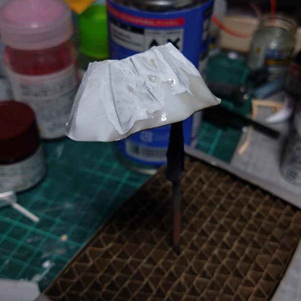 チナッガイ改造の続きです。後頭部はこんな感じになりました。スカート部分は昨日制作。腰のパーツに帯のように巻き付けたプラ板に、台形のようにカットしたプラ板を貼り合わせて制作。瞬間接着剤塗っては瞬着スプレー…でこんな感じに出来ました。 今日は昨日制作したスカートより少し短くしたプラ板をスカート一周以上の長方形型に切り取りライターで炙っては少し曲げ、そしてハサミで上から下に向かって細い3角状に切れ目を入れてその分を無理矢理曲げて瞬間接着剤とスプレーで硬化。その繰り返しで一周回ってできたのがメイド服のフワフワしたスカート状の白い部分っぽいものを制作。まだガタガタですが接着部分の隙間等に瞬間接着剤を裏表両方塗ってスプレーで硬化。その後サーフェイサーホワイトをベタベタと筆塗りしました。現在ここまでですが乾燥後にまた瞬間接着剤塗る予定です。この後ヤスリがけしたりで角を落としていく予定です。多分プラ板髪型制作のようにサフと瞬間接着剤が角を滑らかにしてくれるはず。後は靴なんですが幅広でカッコ悪いので左右半分にカットして真ん中削って接着して幅詰めしました。くるぶしあたりの丸いモールドも削りました。スカートが上手くいけばまた来週末にはかなり進めれると思います。🤔（4枚目）