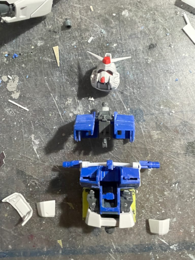 【制作工程02】胴体を改修中。胸部から腰にかけて全く稼働しないので、何とかするべく改造。コクピット部分を突き抜けるように軸を一本通して前後に多少屈んだりできるようにして、細切れした腰ブロックを貼付けています。これによりウラキが乗るところが消失しました。