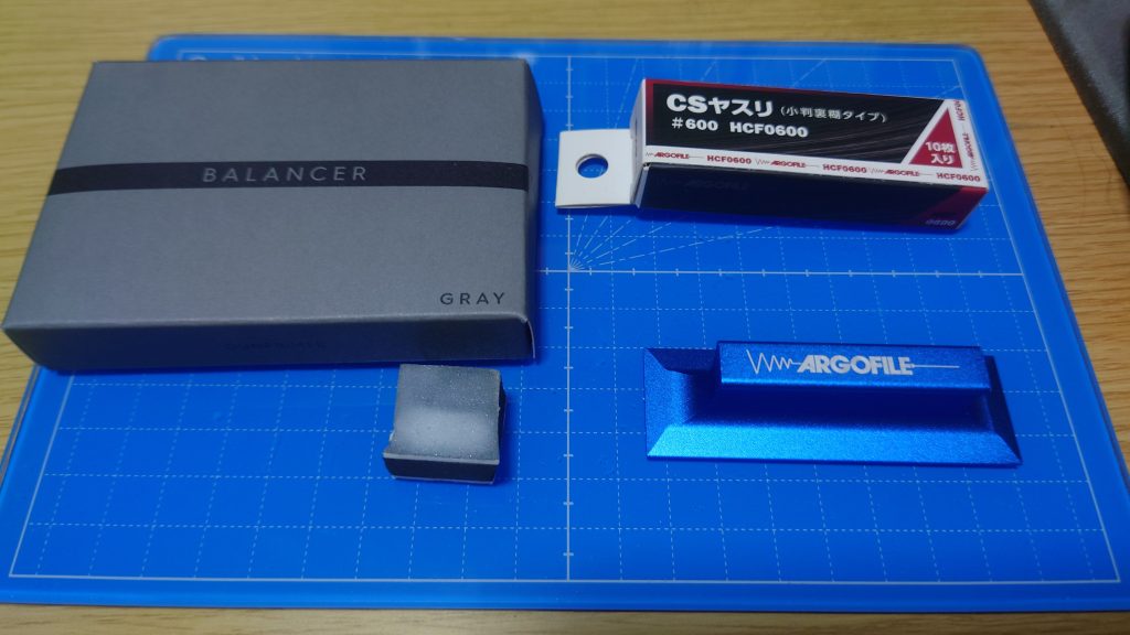 ガラスやすりは曲面の処理は得意だけど直線部にあるゲート処理は苦手。なので滅多に使わないけど紙やすりも使います。使っている道具は・アルゴファイル CSヤスリ#600 + フラットホルダー ～直線パーツ用。ゴリッゴリに削れるので軽く触れる程度に様子見ながらじゃないとパーツまで削れていく強者・GUNPRIMER BALANCER GRAY ～ 600番の研磨跡を2000番台の処理跡にするトンデモ兵器