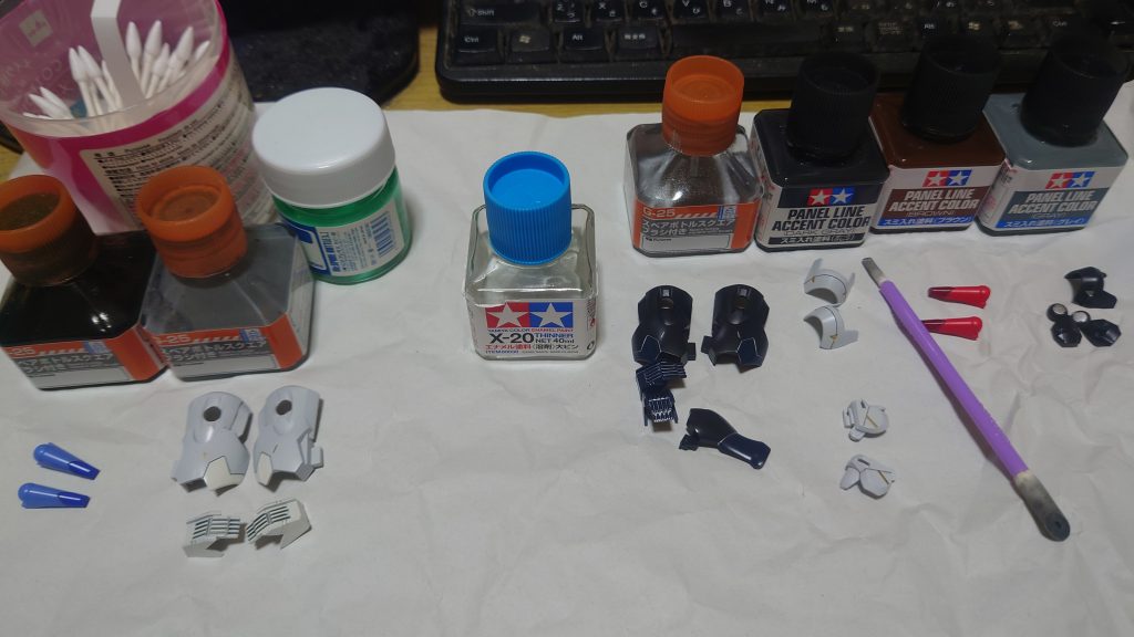 スミ入れ。大半はタミヤのスミ入れ液を使っています。塗布して1時間くらい乾燥させてから・ガイアノーツ フィニッシュマスターで拭います。画像ではそこそこ汚れてますが、パーツに色がつくことはなく普通に使えていますさらに今回はエナメルシルバースミ入れと水性スミ入れも併用しています。シルバーは・ガイアノーツ 速乾性エナメル系溶剤を「１：５」で希釈しています。失敗です。薄めすぎたっぽい。多分使った塗料の場合だと「１：４」でいいかもしれませんでした。一度流して拭った後、もう一度流し込んで発色させています水性スミ入れは一度は聞いたことがあるかもしれない「アクリジョンスミ入れ」です。元々はABS主体でエナメルで破壊されやすい中華プラモのスミ入れ用に作りましたアクリジョンは・クレオス アクリジョン エアブラシ用うすめ液・クレオス アクリジョン リターダーで希釈します。アクリジョンはとにかく溝への伸び(流れ)が悪いです。なので「塗料：うすめ液：リターダー＝１：１以上：１以上」にします。これでも伸びが悪いです。下手したら１：２：２でもいいかも流れにくい時は溝に対してはみ出してもいいのでベタっとなぞります。そして30秒～1分程度でマジックリンで拭きとります。注意点として、アクリジョンは乾燥が早いです。薄めていても早いです。なのでなるべく早く拭き取ります。じゃないと拭き取るときにそこそこな力でゴシゴシしないと取りにくいです。それとこのときは綿棒の方がいいと思います。フィニッシュマスターだと一瞬で汚れる+拭った塗料が伸びてパーツが激汚れますこれが終わったらトップコート吹いてエアブラシ完了です。面倒くさがりなので、トップコートは砂吹きなどせず最初からビタ濡れの一発吹き。ネットでは白化するとか目にしますが、今のところ今まで一度も遭遇したことがないです