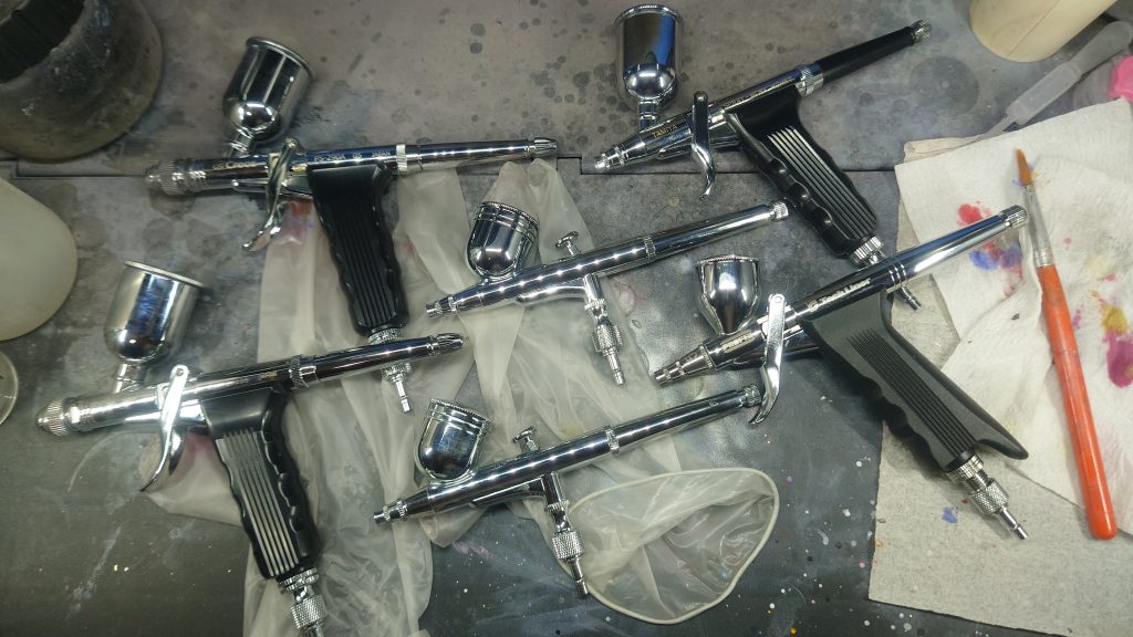 塗装はほぼすべてエアブラシで行なってます。吹く塗料毎に使い分けてます。使っているのは・クレオス トリガータイプ0.5mm ～サフ用とソリッド用の2本。吹く面積と数が多いので口径が大きい方が楽になります。何よりトリガータイプは指が疲れにくいのでオススメ・Ausuc ダブルアクション0.3mm ～クリア用と蛍光塗料用の2本。分ける必要あるかなと思いつつ安かったのと、吹くパーツの面積と数が少ないのでボタン式でいいやと思い購入・RAYWOOD PROFIX Tech Liner ～メタリック用。最初はボタン式の別機種を使っていたけど、メタリックを吹くことが多く、指がご愁傷レベルで痛くなったのでトリガー式に変更。粒子が詰まらないように0.5mmのニードルで使ってます・タミヤ スプレーワーク0.3mm ～トップコート用。サフ、ソリッド、トップコートは安心信頼の国産で揃えてます。