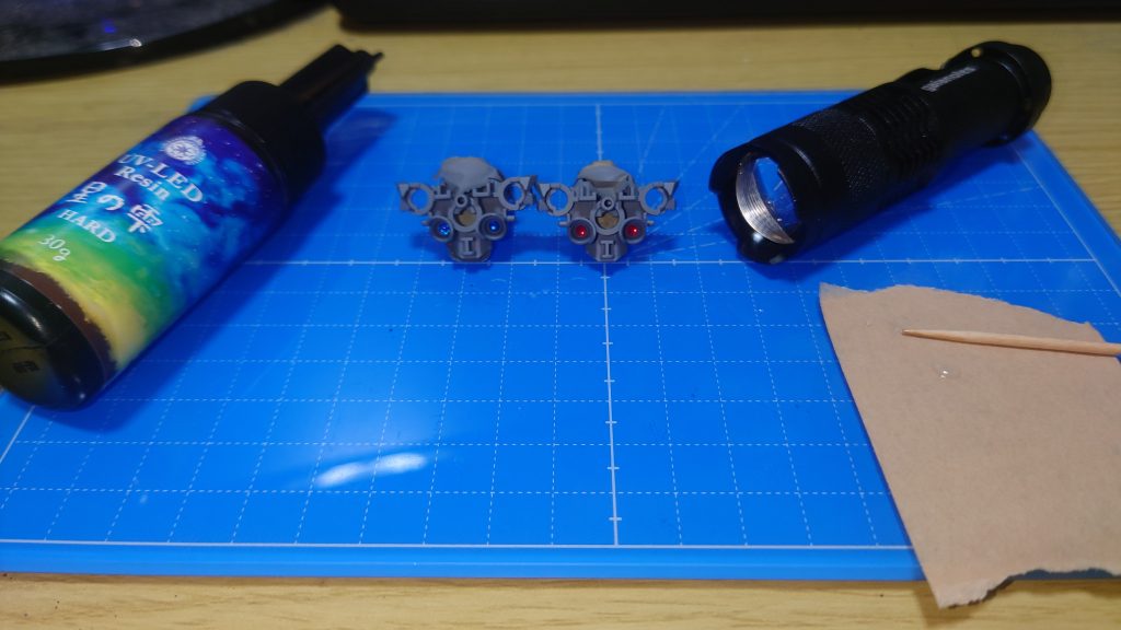 最後に一工夫。エアリアルの胴体部分にハイキューパーツの円形メタリックシール 2.2mmを貼ります。その上に・パジコ UV-LEDレジン 星の雫を塗布してレンズ状にします。レジン液はガムテープの上に適量出してつまようじで塗ります。使わず余ったレジン液は硬化させるときに使うUVライトで硬化させれば廃棄しやすくなります