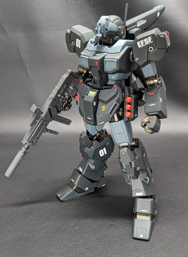 前面から。見える部分の改修としては胸部、フロントアーマー上部、太もも、すね下部、足先への新規スジボリ追加。また、肩アーマーと前腕は合わせ目消ししています。フロントアーマーのV字は付属シールを切り抜いてマスキング塗り分けしました。また、頭部バイザーの丸モールドと肩アーマーの丸スラスターはエナメル筆塗りで塗り分けです。