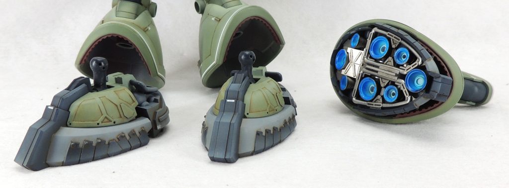 ■脚部　接地性を向上させるため、足首のボールジョイントをプラ材で5.0mm延長しました。強度と剛性を確保するため、φ1.0mm真鍮線で軸打ちを行っています。　その他、スカート前側のフチにエバーグリーン製の凹凸モールド入りプラ板のスライスを接着して見栄えを良くしています。スジ彫り・ピンバイスによる開口・プラ材の貼付け等により、ディティールを追加しました。　足の周囲には極小の丸型リベットのモールドを24個貼り付けて、他のドム作品と差別化を図っています。 