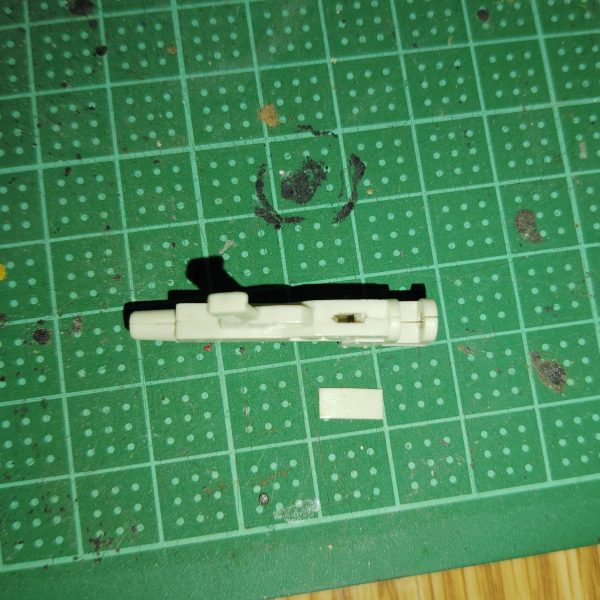 　ビームライフルのストーリー投稿第９弾です。　今回は、前回予告した追加パーツをビームライフルに取り付けるための下準備を行います。　もともと陸戦型ビームライフルの銃身下部にあったエネルギーパックと思しきパーツを、ヤスリとデザインナイフで切除していきます。　空いてしまった隙間は、パテなどで埋めるよりも手っ取り早いのでは、と考え、0,3mmのプラ板で塞いでしまいました。　前回のスコープと同様、最終的にはパテなども使ってわずかな段差なども完全に埋めてしまいたいのですが、それはある程度加工がすんでからになりそうです。　これで下準備が整ったので、次回からようやく追加パーツを製作していきたいと思いますが、本日プラ板を切り出した段階で、作業量とその手間がなかなか大変そうだと予想できてしまいました・・・。　完成まではまだまだ掛かりそうなうえ、次回完成品として投稿するモノはこのビームライフルとは全く関係ない機体なのですが、どうか気長に、ネタバレなしでお付き合いください。（3枚目）