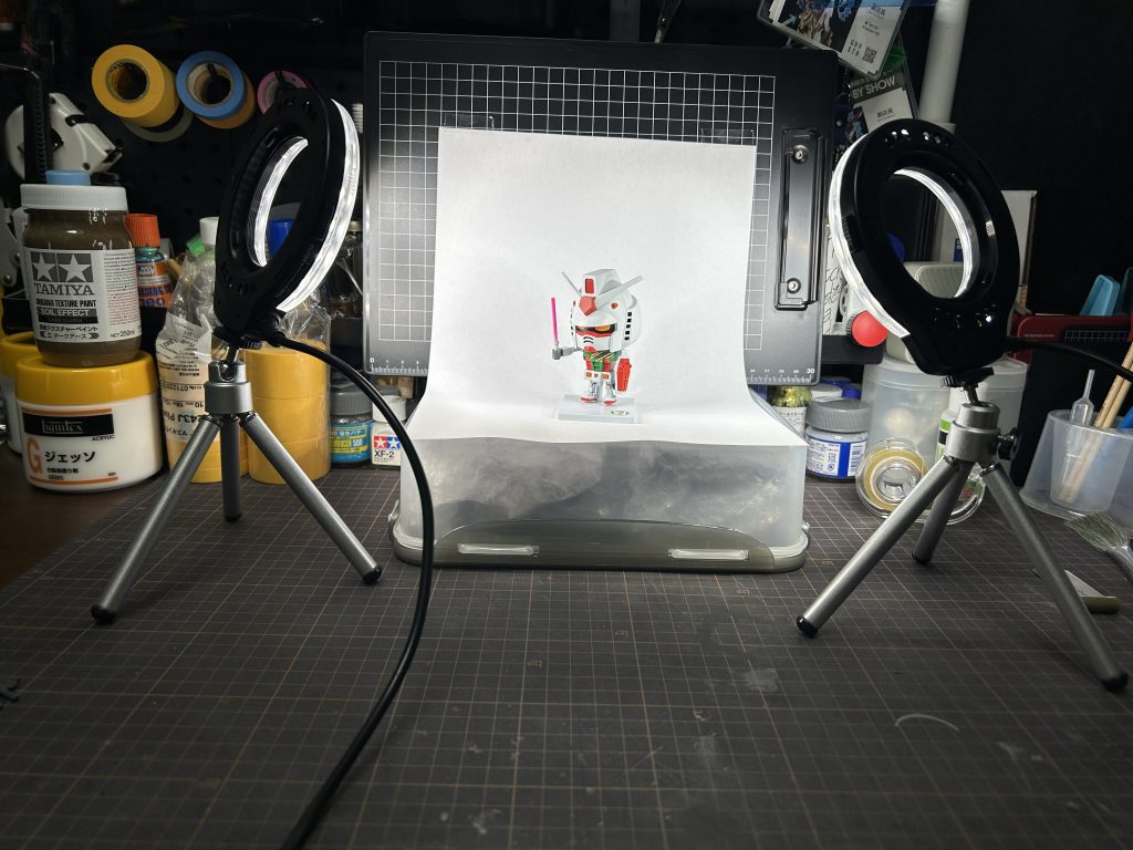 スーパー撮影ブース。クリップボードにA4コピー用紙を貼り高さ出すために前回投稿作品が入ったタッパーを使用。撮影セット全部引っ張り出すの大変疲れます。