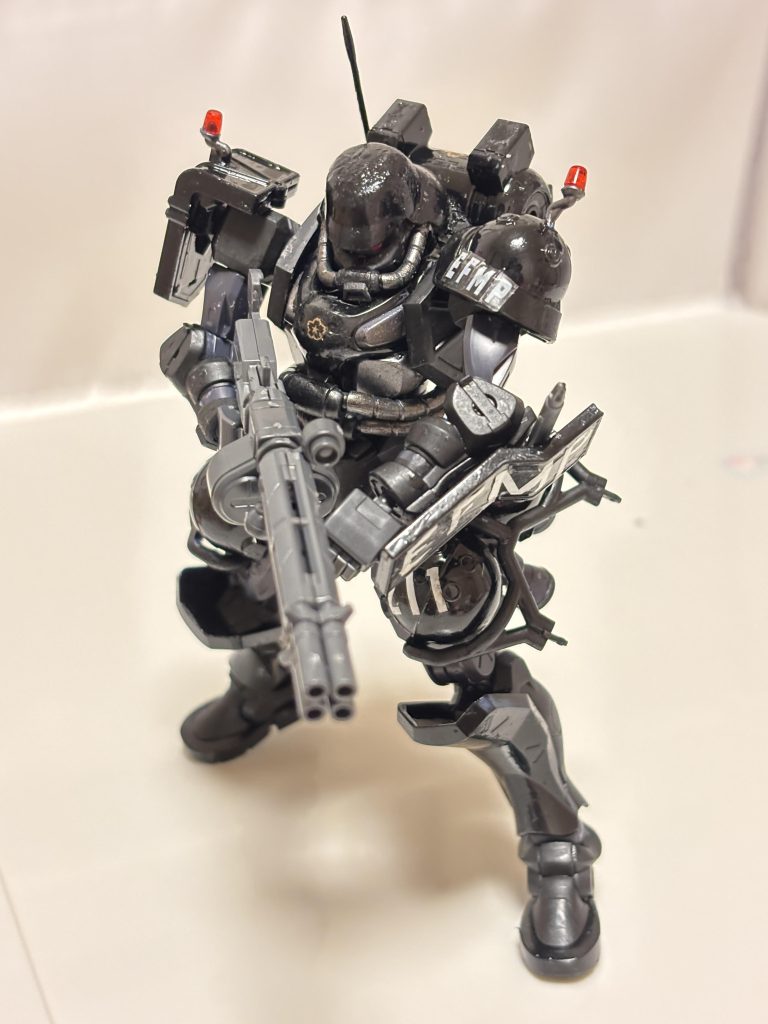 もはや何番煎じかわかりませんが、プロテクトギア風軍警ザクです。半光沢の黒と、つや消しの黒で塗り分けています。当初は、トップコートは吹かない予定でしたが、てかてかしていると写真が撮りづらく、デジラマにも加工しづらかったので、やはり吹きました。こちらの画像は、トップコート前のものです。写真だとわかりにくいですが、実物は違っている部分とつや消しの部分の質感に差が出て気に入っていました。まあ、トップコート後も質感の差は残っていますが。でも、写真ではつたわりづらい笑