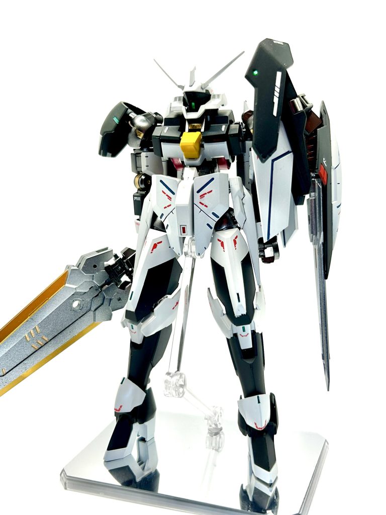 正面。全体はレギンレイズ腰はグレイズ、フロントアーマーと右肩はマンロディ、バックパックはジークルーネのサイドアーマー、つま先はグレイズ、サイドアーマーはウイングガンダムゼロ炎に変更しています。 イメージとしてはOOクアンタやガンダムローズのような左肩がシールドで騎士のような見た目にしたかったので、とりあえず満足です。また、頭部も少し派手にしたくてジークルーネのパーツを付けて大型化しました。