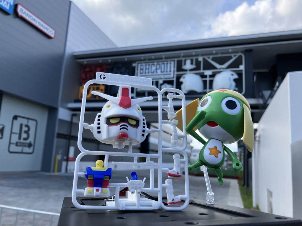 『ここが、バンダイの新たなる剣、BANDAI HOBBY CENTER  PLAMO DESIGN INDUSTRIAL INSTITUTE略して、「PDⅡ(ピーディーツー)」でありすか。来年本格稼働すれば3年前と比べ、約35%も増産が可能!?  サイコフレームの反応速度に匹敵するだとッ!?』 『ガンプラくんも心なしか喜んでいるようでありますな❤️』