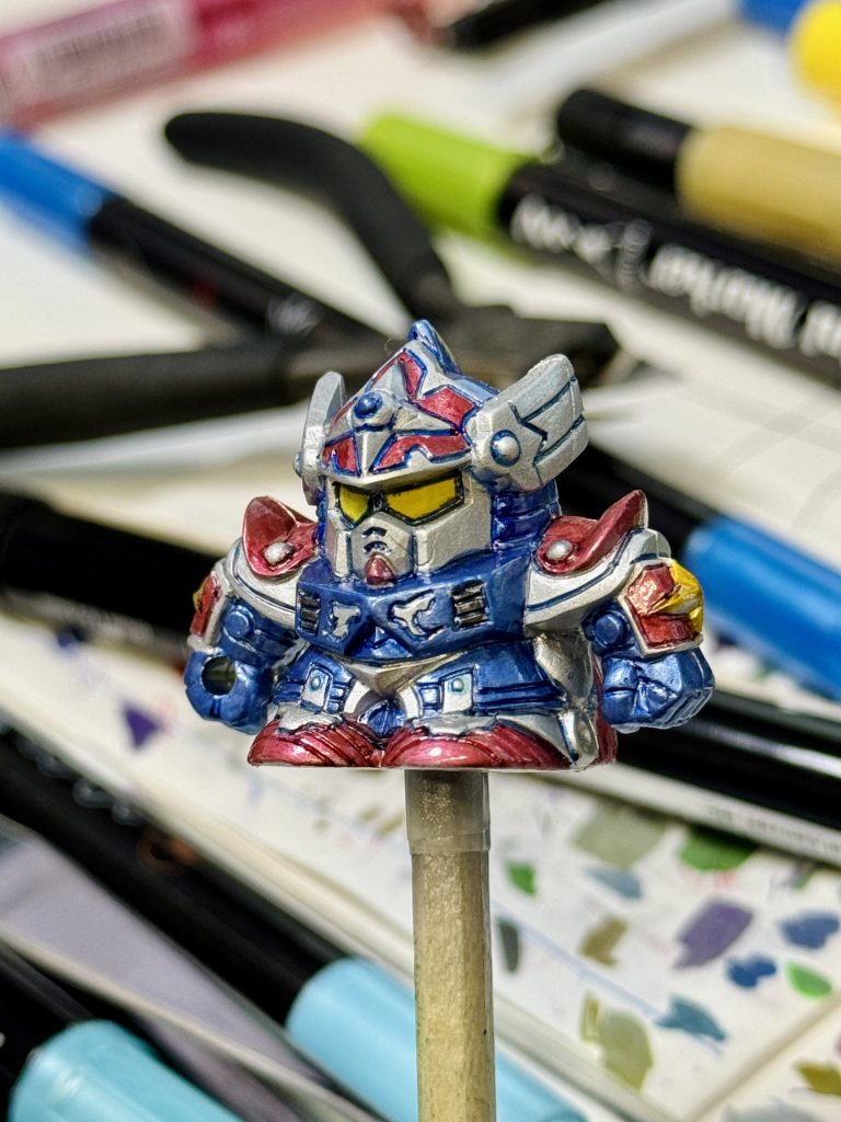 全体を塗ったら、一度ダイソーのラッカースプレークリアを吹きかけ、硬化させます。この上からなら、墨入れはHI-TEC-Cの0.3mmで書き込めます。