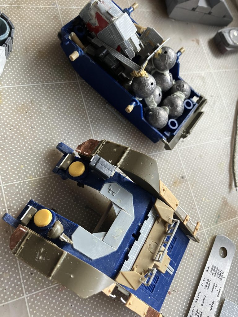 4月ごろ、車体がほぼ完成です。フェンダーやリフトを作ってます。上の方のパーツには、変形のために作った胴体ブロックが見えます(1回で上手くいかず作り直しました)。その右側へは前傾の時こけないように、釣り用の鉄球を詰め込んでます。