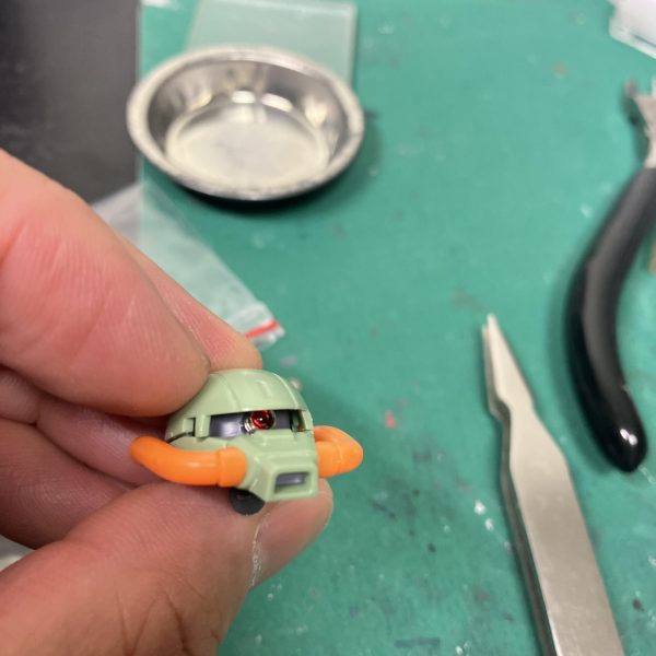 HGハイザックカスタムA.O.Z、メタルパーツの予定地をピンバイスしつつ、モノアイに気を回します🥴ですが、カッコいいザクヘッドなんですがスリットが細く、♻️回転軸も奥にあるのでなかなか目つき悪目🫤ていうか角度によっては中が見えないですね🫩かといってやはりワンサイズ大きいとアンバランスに😑（📷2/4）とりあえず外径2.5mmですかね😉あと、この濃い色系のプラは太ゲートは高確率で白化するので苦手😭2度切りも通じん時があるので😰（3枚目）