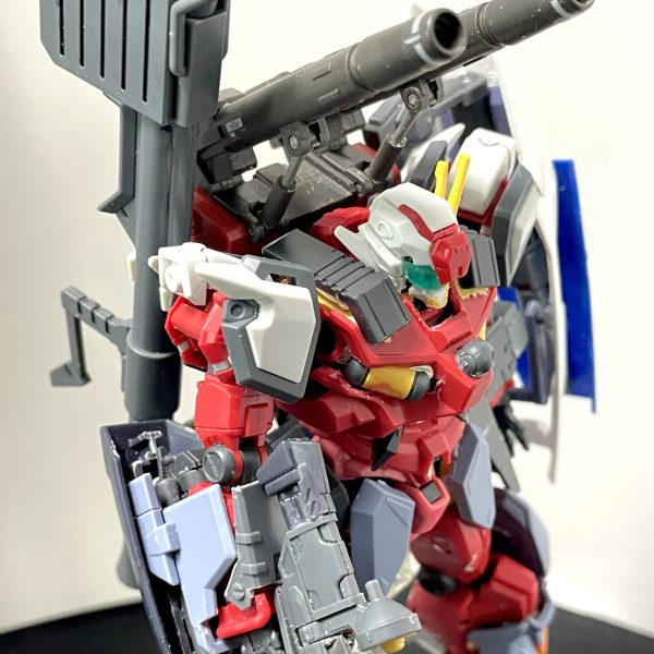 軽キャノンはGQガンダムより腕や脚が気持ち太くはなっていますが、ボディの大きさと比較するとボリューム不足に思えた為、デュエルブリッツのアーマー部分をミキシングしてマッシブになればいいなと作成開始しました。脚部は排気ダクトとスラスターを追加し、デュエルブリッツの追加装甲を装備バックパックはオリジン版ガンキャノンのビームキャノンに変更、ハイパーバズーカとシールドをマウント頭部は01ガンダムのようにV字アンテナをつけようとしましたが、キャノンと干渉するので、サイドに設置腰は広すぎるように思えたので、赤いガンダムの腰に変更し、フロント、サイド、リアと装甲追加胴体はタンクを中に埋め込み、肩にはミサイルコンテナのような蓋を追加肩はデュエルブリッツの肩アーマーを前後に取り付け、上部にはゼフィランサスの肩パーツをつけています。腕にはデュエルブリッツの装甲をつけていますが、ランサーダートやスレイプニールは流石に合わなかったので二連装ビームライフルっぽいものを右腕に、左腕にはジェスタのビームサーベルラックを装備ビームライフルは軽キャノンのビームライフルにデュエルブリッツのビームライフルパーツを切って貼って長さをアップまだテープで仮止めの箇所ばかりですが、軽キャノンとデュエルブリッツ装甲は新しいキットなのでサイズ的にはフィットしている気はしますね。（1枚目）