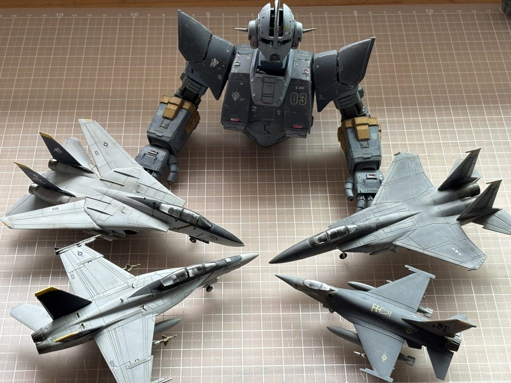 ジオングの右側が米空軍の制空迷彩F15,F16。左側は米海軍VF84所属の記念塗装されたF14,F18です。ジオングと同じ1/144スケールです。自分基準では殆ど汚してないです。このへんの色目と仕上がりを基準に、ケーニヒス・ジオングの塗装方針を決めました。上半身は制空迷彩のグレイをジュラルミン色の上に塗ります。下半身の方は、海軍機の退色表現をベースにして、スターウオーズ流のストレーキを一発勝負で油彩で入れます。両腕のイエローの差し色をメインにして、赤と緑のパーツはぐっと色調をおさえました。