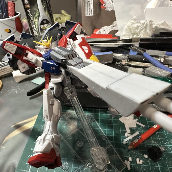 ツインバスターライフルの両手持ちのストレスを無くすべく手首角度をつけてみました。切ってはるだけなんですが中々大変でした。プラ棒の切断角度が合わないんですね。切り飛ばしたプラ棒が行方不明になど中々難儀でした。 オーバーパース用のパーツもプラ板を2枚づつ貼り付けライフルが連結しているような風にいじりました。 プラ棒の墓場がw（6枚目）