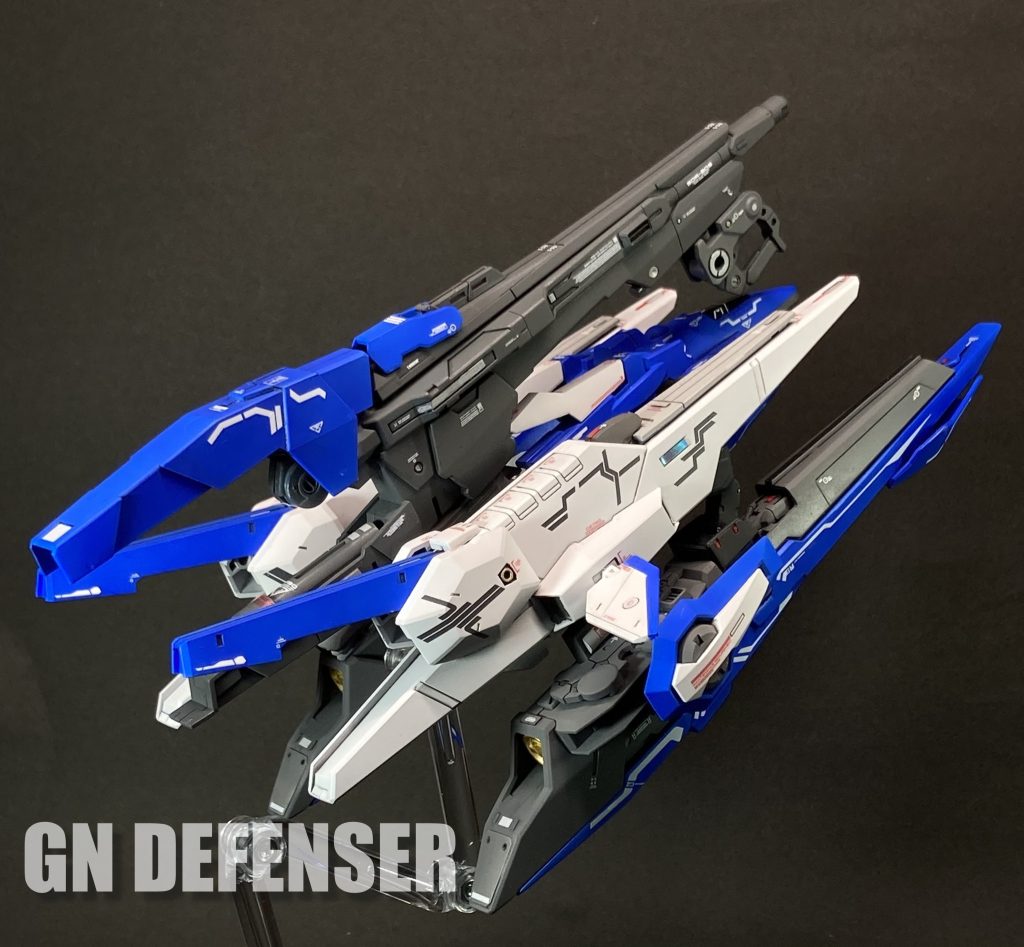 GNディフェンサー ① アストレアのオプションとして開発された可変戦闘機。GNコンデンサーを内蔵し、単体でも高い戦闘力を有する。主兵装であるGNメガキャノンもまたGNコンデンサーを内蔵しているため単独でも使用可能ではあるが、アストレアと合体してGNドライヴと接続することで最大の威力を発揮する。 このGNメガキャノンは再設計とダウンサイジングを経て、GNソードIIブラスターとしてダブルオーガンダム セブンソード/Gに実装されることとなる。