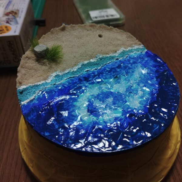①砂浜に岩と草で少し表情を付けました。･･･が、ちょっとわざとらしい気がします。…②海に色をのせました。舞台は瀬戸内の屋島なのに、ちょっと南国過ぎる気がするのでもう少し濃い色を被せるつもりです。…③穴の位置に松を植える予定松は、ダイソーの針金に、ダイソーの軽いねんど(黒)を木工ボンドで溶いたモノを塗ってます。乾いたら松葉をのせます。（1枚目）