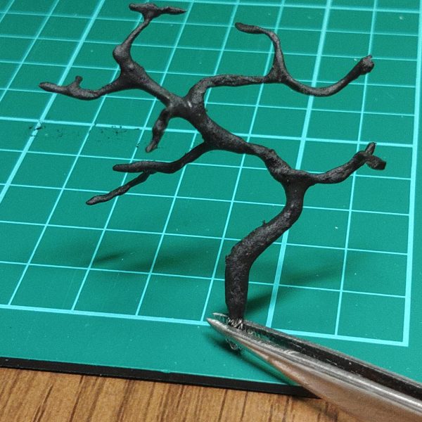 ①砂浜に岩と草で少し表情を付けました。･･･が、ちょっとわざとらしい気がします。…②海に色をのせました。舞台は瀬戸内の屋島なのに、ちょっと南国過ぎる気がするのでもう少し濃い色を被せるつもりです。…③穴の位置に松を植える予定松は、ダイソーの針金に、ダイソーの軽いねんど(黒)を木工ボンドで溶いたモノを塗ってます。乾いたら松葉をのせます。（2枚目）