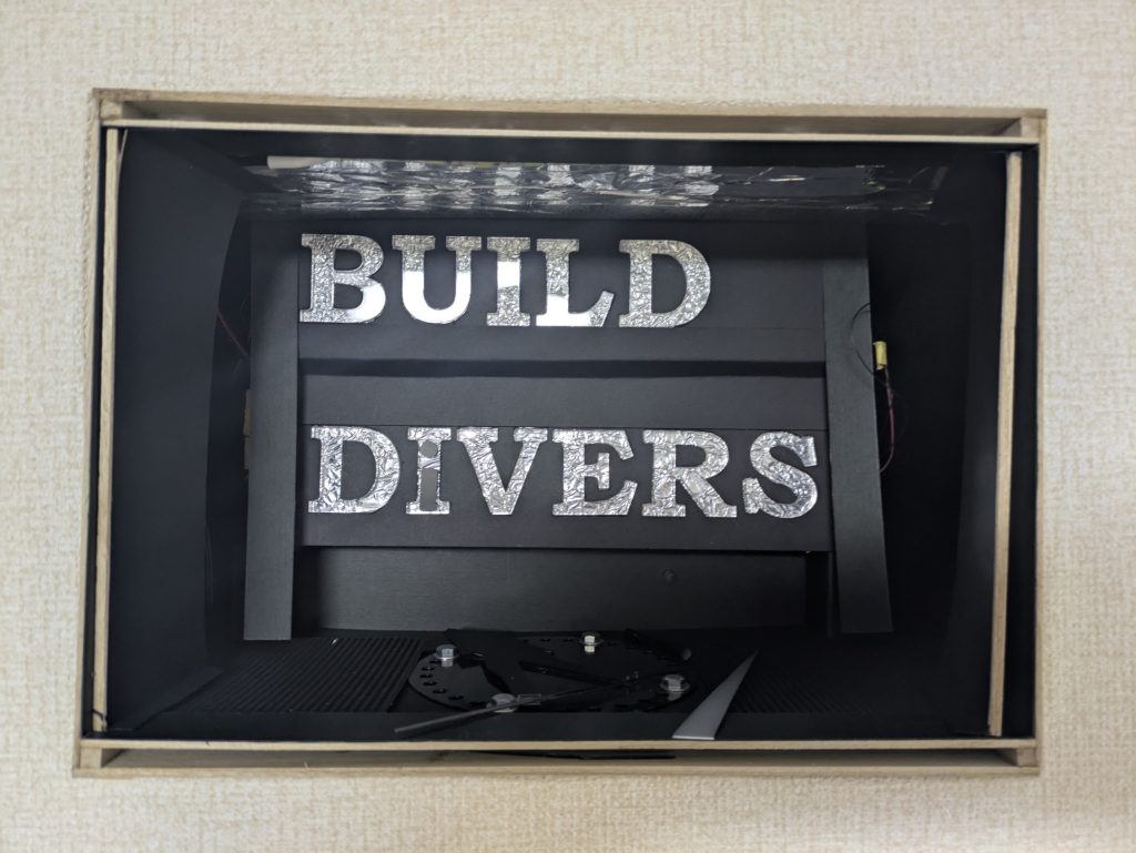 背景。LEDで光るようにはした。ホームセンターで材料探しに行ったとき、アクリル文字があって、これで文字作れるかなー「BUILD DIVERS」つくれるやん、というわけで買ってしまい、買ったからには使わないと・・・www購入するとき、単語のスペルを何回も確認した一応、「DiVERS」の小文字の「i」も再現。