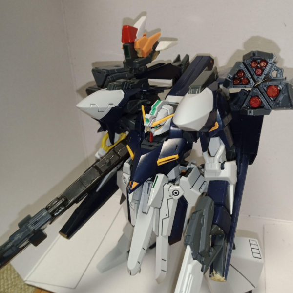 6年前の画像が見つかったのであげておきます…。当時AoZを読んでいて、2号機はガンダムフェイスなのかと思い作っていました。近年プレバンで販売していたヤツですね。コンセプトはエリアドミナンスではなく、長距離砲撃機でした。ハルートのGNドライヴでセンサーを作り、数種類の弾頭を装填したミサイルポッドを追加。色々なジャンクでメガビームライフルをでっち上げました。バインダーもメガ粒子砲をカットしてシールドブースターにしていたと思います。画像は残っていませんが、オプションとしてギガンティックアームユニットならぬギガンティックレッグユニットや！と思い、ハルートのバックパックとレギンレイズジュリアの脚で作成していたのですが、後から既に存在していることを知りました。可変すると量産型ビグザムみたいになって当時は満足していました。いつかフルドドIIを手に入れたら左肩もクローユニットに換装してやろうと思って時が過ぎ今に至ります。ちなみになんですが、なんとフェイスパーツにはA-Zガンダムが使用されています。当時はこんなに貴重なものになるとも思わずにパーツはバラバラに改造素材にされていきました。（1枚目）
