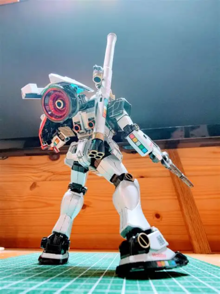 横浜ガンダムの余剰パーツを使って、まずスカートを換装し、肩アーマーと足首アーマーを改造、ビームスプレーガンを、ガンダム用ビームライフルに取り替え、バズーカをバックパックに取り付け、RGジオングの余剰パーツを使って大型スラスターを追加装備し、むき出しだとアレなんでリライズ系の余剰パーツを使ってカバーみたいなのを取り付けました。そしてシールドの先端にはサザビー用のファンネルを1基装備。