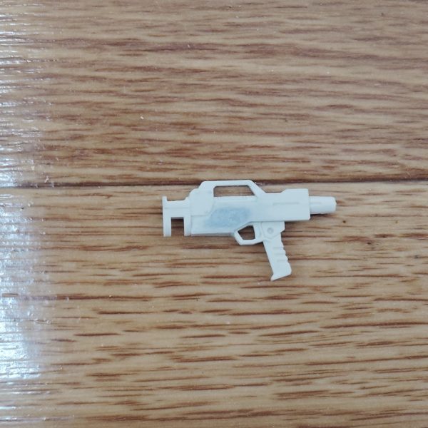 　ビームライフルのストーリー投稿第１１弾です。　今回は、前回から製作を始めた追加パーツをビームライフルに取り付けるための下準備をもう少し行います。　もともと陸戦型ビームライフルの銃身左側にあったディテールをパテで埋め、ヤスリとサンドペーパーで平坦にしていきます。　これで、銃身右側と同じくシンプルなデザインになりました。　さらに、追加パーツを取り付けた際に隙間ができないよう0,3mmのプラ板をカットし、追加パーツを取り付ける下地部分に貼り付けます。　ついでに、もともとビームライフル側面にあった四角というかいびつな六角形のディテールに付いていた小さなピン状のディテールも、デザインナイフでひとつ切り飛ばしました。　これで追加パーツを取り付ける下準備が整ったので、次回から追加パーツの仕上げをしていきたいと思います。　大方ゴールが見えてきたとはいえ、完成まではもうしばらくかかりそうですが、どうか気長に、ネタバレなしでお付き合いください。（3枚目）