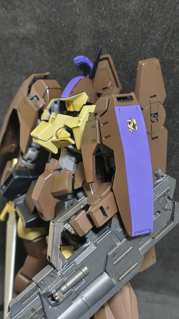 カラーリングはレギンレイスのイオク機とグレイズリッターのカルタ・マクギリス機の折衷な感じで。トサカと肩側面の紫は、カルタ(赤)とマクギリス(黄色)の差し色が色相環でベースカラーから反時計回り120°付近だったので、ダークイエローとレッドブラウンの中間色あたりから反時計回り120°あたりということで紫(ブルーバイオレット)を選びました。