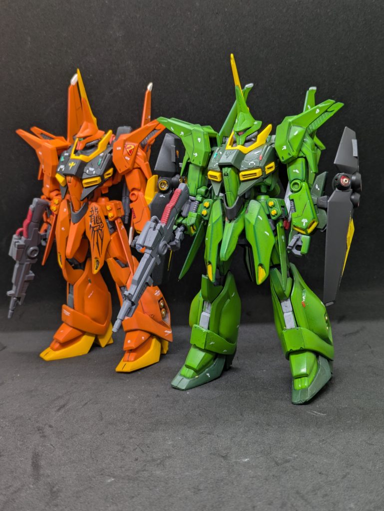https://gumpla.jp/hg/2364960グレミー機と並べてみました。 塗装です。濃い緑→黒→濃緑色。明るい緑→黒→デイトナグリーン→ルマングリーン。結局ガルスJみたいない色になってしまいましたが、メイン色の下に一色、別のグリーンを噛ませたので、少し深みが出たと思いません？（自画自賛w）