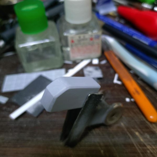 引き続き武装制作。プラ板箱組みからパーツを制作。自分は面倒くさがりなので（笑）精度をあまり気にしなくても良い部分は大体サイズ合わせて切り出し、接着部分のすり合わせをして接着します。(ガイドパーツになるように左右の広い面のパーツはしっかり同じ物を作っておきます。)この時に接着剤を多めに塗るのがポイント。合わせ目消しと同じ原理ですねぇ～少し接合部に隙間が空いた場合は瞬着で埋めておきます。そして乾燥後にC面作る場合は角の部分を金ヤスリで出来るだけ均一になるように削ります。この後は仕上げにペーパー掛けて完了。 直線的な物は割と簡単に作れるので楽ではありますが、曲面のパーツの場合はパテも使って整形しないといけないのでキレイに作るのは大変ですねぇ～  （6枚目）