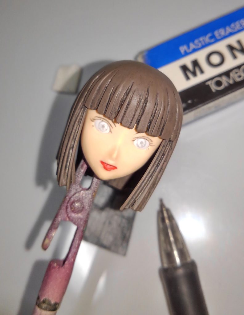 今回はシャープペンで眉、まつ毛、アイライン、瞳を書いていきます。うまくやるコツは・・・気合です! 気合で何とかします。消しゴムで消したり、下地が塗装ではないのでヤスって修正しても構いません。表面がつるつるして書けない場合は、400番くらいで軽く表面を荒らしてください。私はよくあるHB芯でやってますが、柔らかい芯とかでやってもよいかもですね。